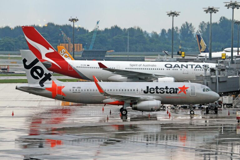 Commercial airplanes from Jetstar and Qantas on runway, perfect for travel stock photos.