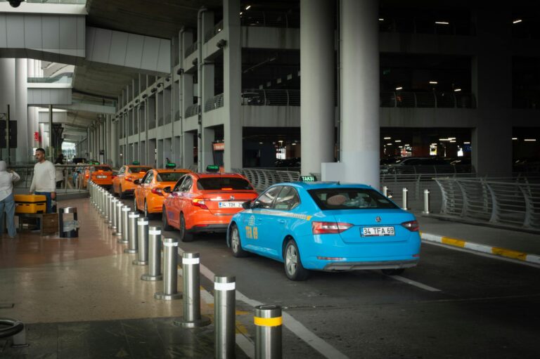 Vibrant taxis lined up at Istanbul Airport arrival terminal with passengers and drivers interacting.